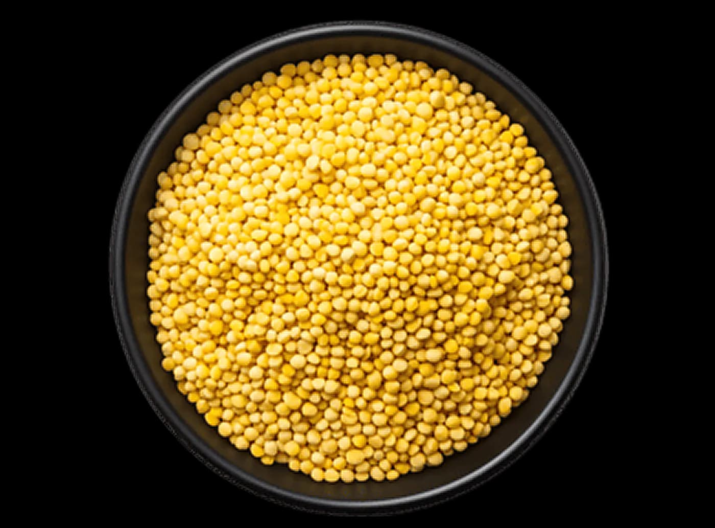 Black ceramic bowl filled with golden millet grains