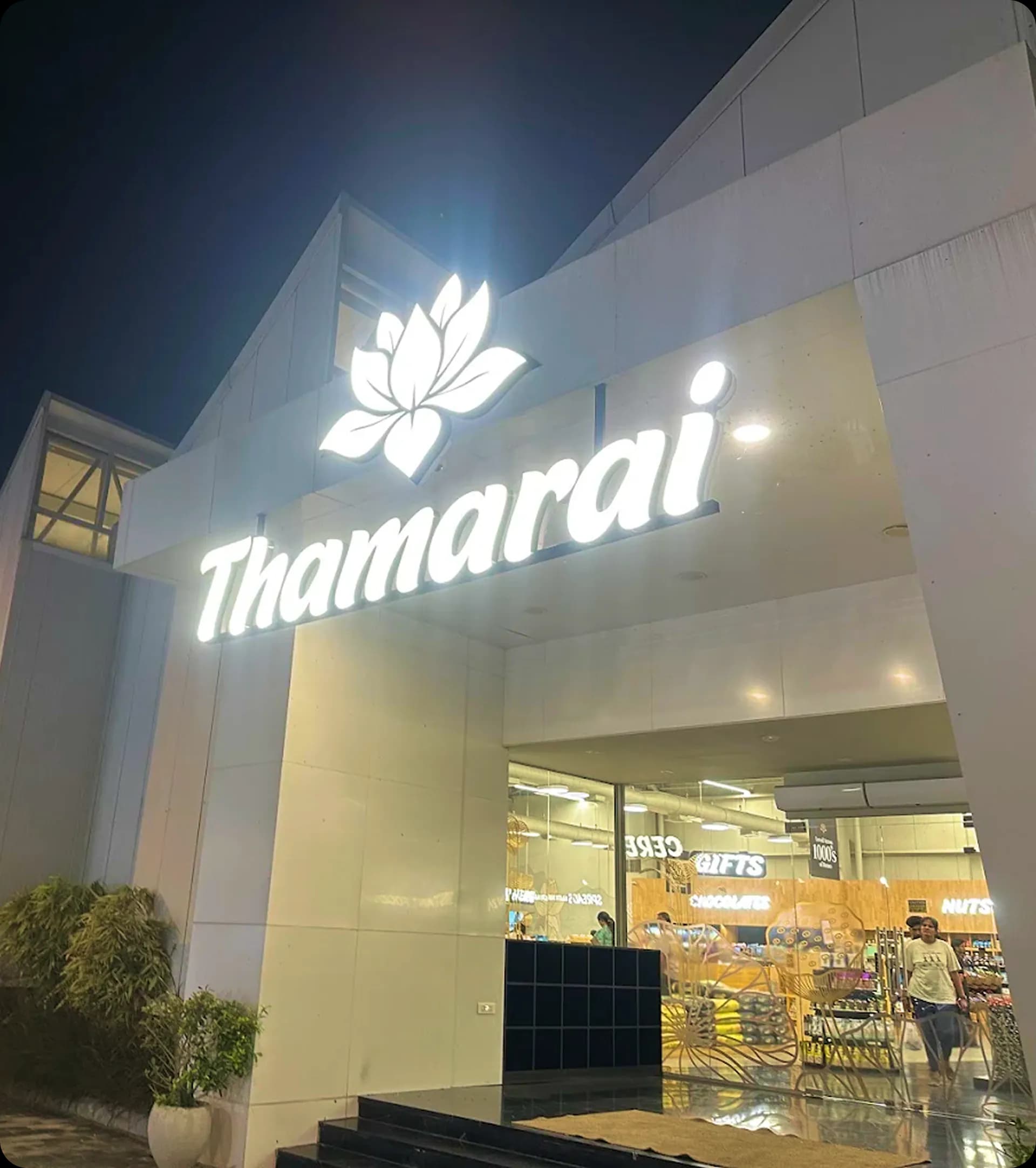 Thamarai storefront at night with a glowing lotus sign